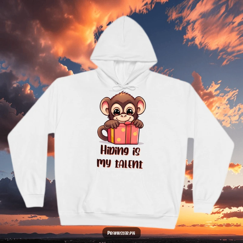 Funny hoodie showing a mischievous monkey concealing itself behind a bright gift box, hinting at a playful prank.